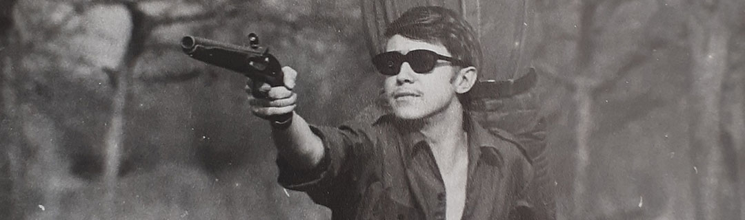 Student im Wald mit Sonnenbrille und Duell-Vorderladerpistole