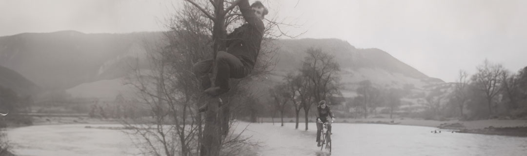 Überschwemmungsszene mit einem Studenten, der sich auf einen Baum rettet, und einem Radfahrer auf der Straße im Zentimetertiefen Wasser